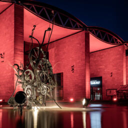 Night of Light in Switzerland, red illuminated Tinguely museum in Basel reflecting in the fountain in front of it